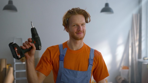 Vrolijke man poseren met schroevendraaier in nieuw appartement tijdens huisreparatie
