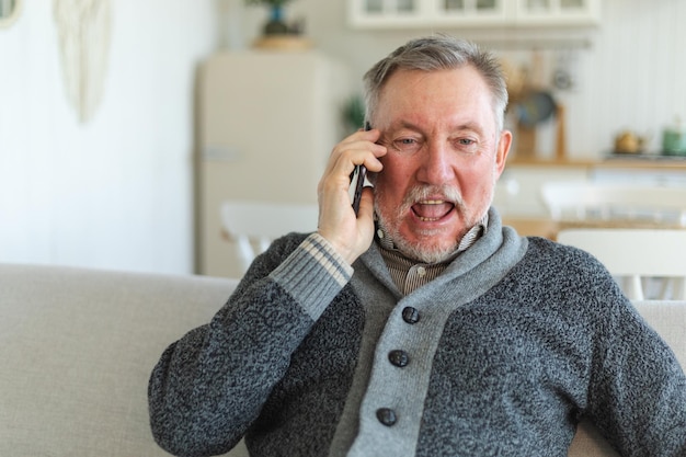 Vrolijke man van middelbare leeftijd die op een smartphone praat met familie, vrienden, oudere volwassen grootvader met