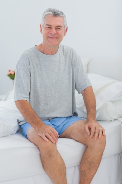 Vrolijke man zit in bed