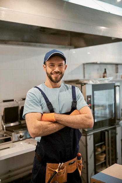 Vrolijke mannelijke werknemer die in de cafékeuken staat