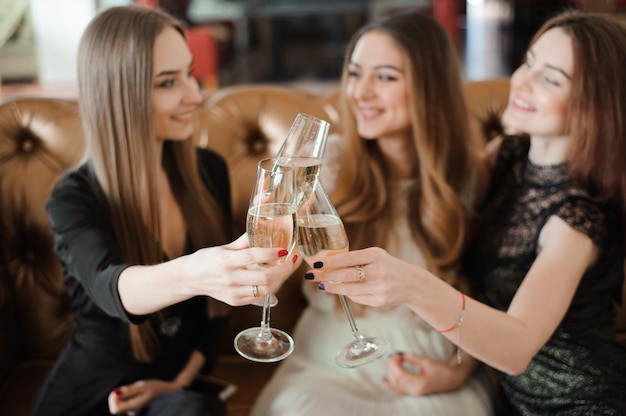 Vrolijke meisjes rammelende glazen champagne op het feest