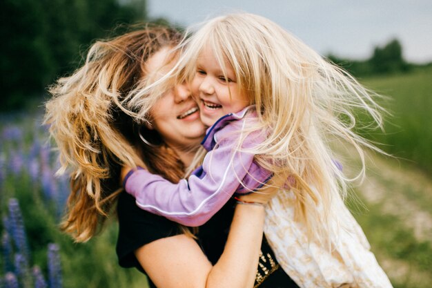 Vrolijke moeder veel plezier met haar dochtertje op de natuur