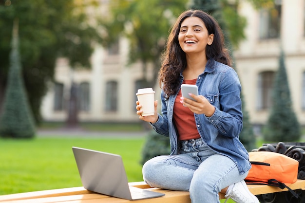 Vrolijke mooie jonge Indiase vrouw universiteitsstudent die aan een project werkt