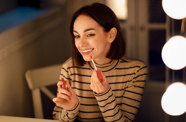 Vrolijke mooie vrouw lippen kleuren en glimlachen