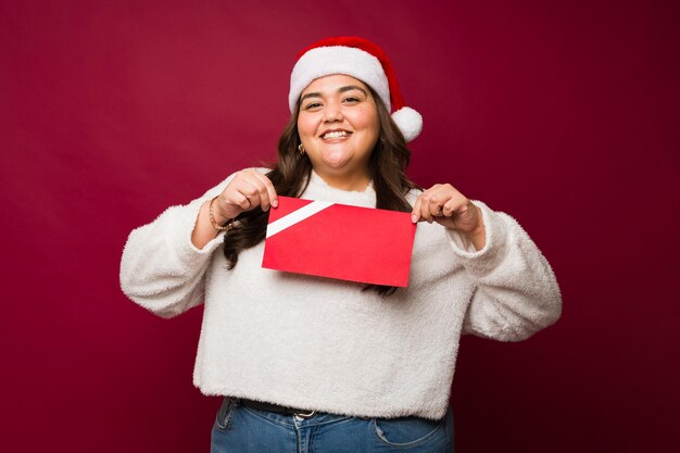 Vrolijke obese vrouw met een mock-up kerstcadeau certificaat