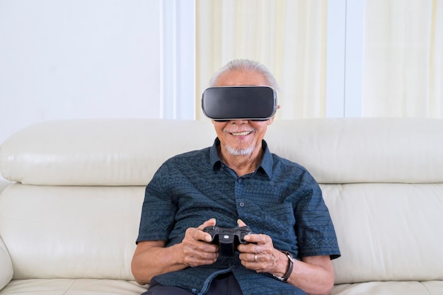 Vrolijke oude man die een videogame speelt met een VR-bril