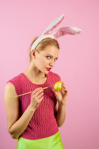 Vrolijke paasvrouw met konijnenoren die ei paasdag concept witte konijn paasei-ideeën schilderen