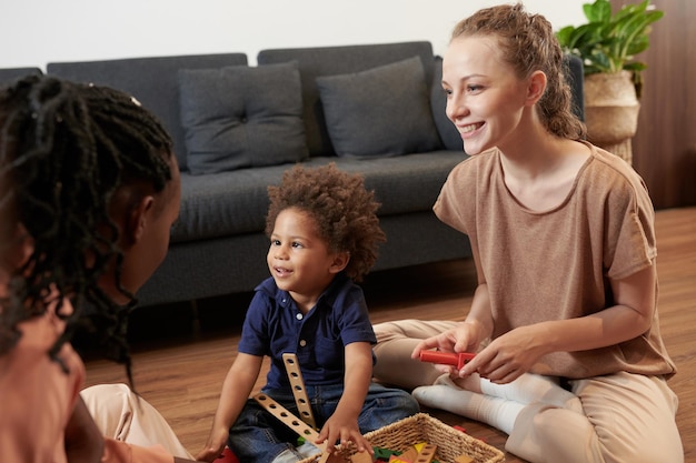 Foto vrolijke peuterjongen die graag thuis met ouders speelt