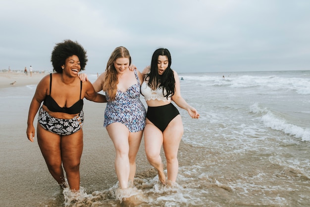 Vrolijke plus size vrouwen genieten van het strand