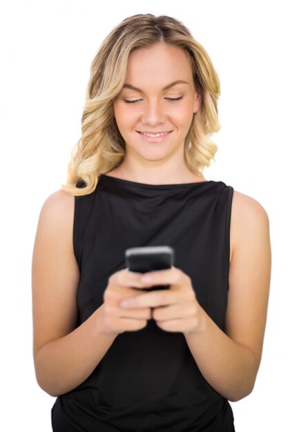 Vrolijke prachtige blonde in zwarte jurk texting