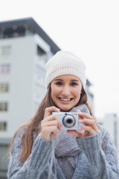 Vrolijke prachtige vrouw met winterkleren op het nemen van foto