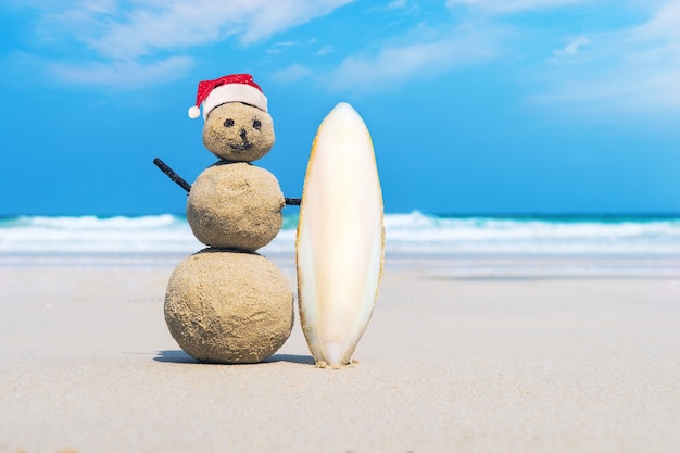 Vrolijke Sandman van wit zand op het schone strand van een exotisch eiland op de achtergrond van blauwe zee en bewolkte hemel. Zand surfer. creatief idee van surfen. het concept van watersporten