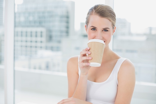 Vrolijke schattige blonde koffie drinken