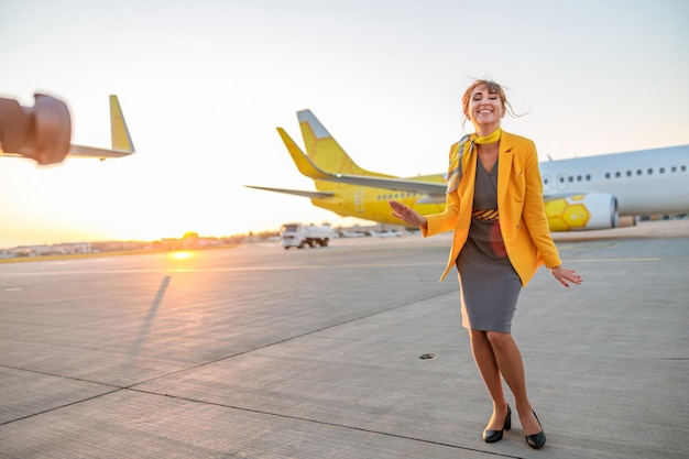 Vrolijke stewardess die plezier heeft voor de vlucht op de luchthaven