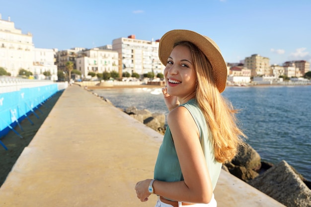 Vrolijke stijlvolle vrouw draait zich om en lacht naar de camera op Crotone promenade Calabrië Italië