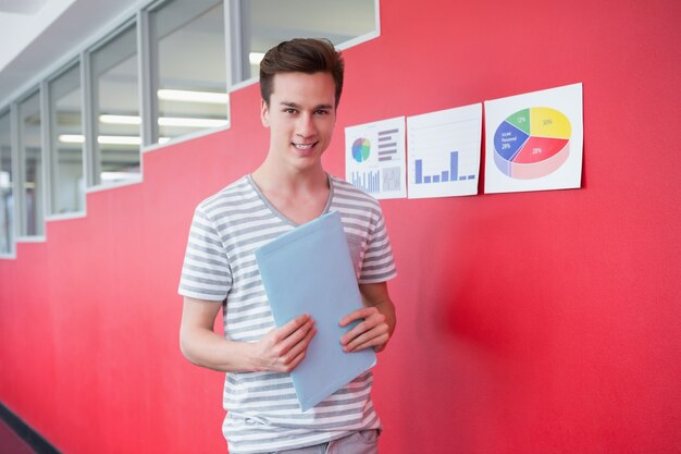 Vrolijke student bedrijf laptop staan