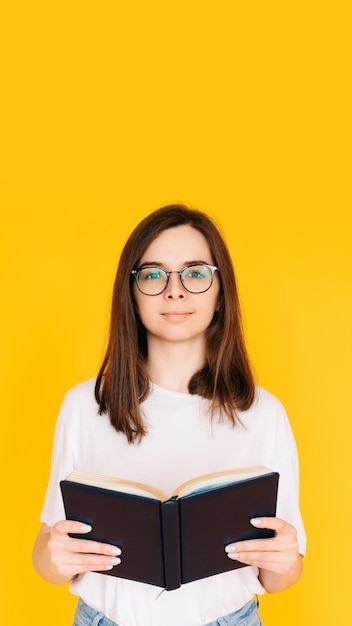 Vrolijke student ondergedompeld in het lezen Vrolijke vrouw met een bril die geniet van een nieuw boek Onderwijs een