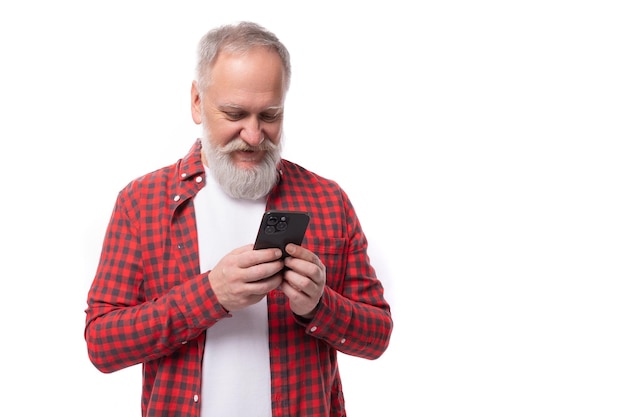 Vrolijke succesvolle jarige grijsharige gepensioneerde man met een baard en snor meesters telefoon