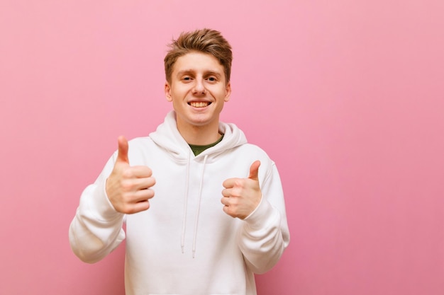 Vrolijke tiener die gebaar toont zoals op roze muurachtergrond