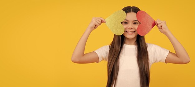 Vrolijke tienermeisje met Valentijnsdag hart op gele achtergrond lieverd Kid meisje portret met hart liefde symbool horizontale poster Banner header met kopie ruimte