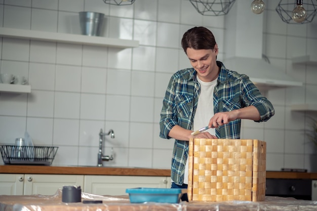 Vrolijke vakman die de buitenkant van de doos schildert