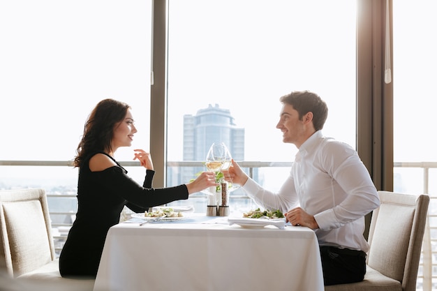 Vrolijke verliefde paar zitten in restaurant binnenshuis