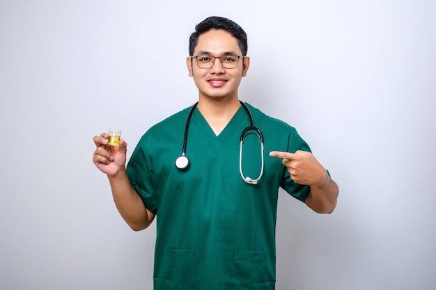 Vrolijke vriendelijke aziatische mannelijke arts arts die urinepotmonster wijst en toont