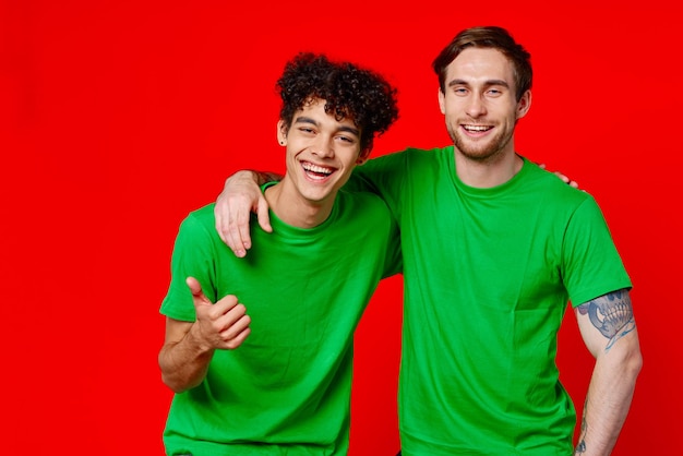 Vrolijke vrienden in groene t-shirts omhelzen communicatie positief