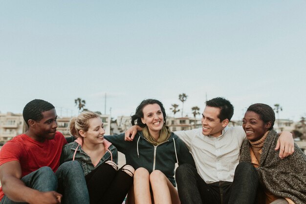 Vrolijke vrienden knuffelen op het strand