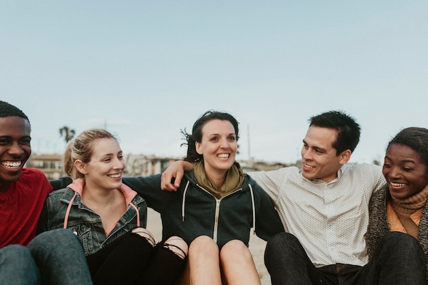 Vrolijke vrienden knuffelen op het strand