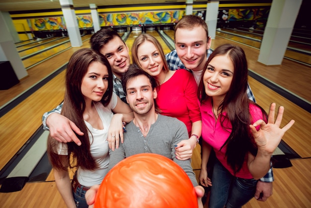 Vrolijke vrienden op de bowlingbaan met de ballen.