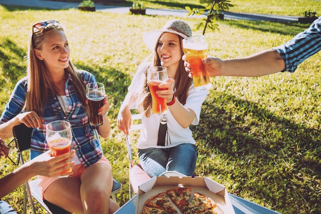 Vrolijke vrienden op picknick in het park. Pizza eten