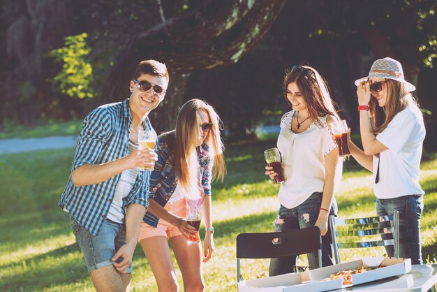 Vrolijke vrienden op picknick in het park. Pizza eten