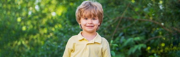 Vrolijke vrolijke jongen Gelukkige kinderen jongen jongen Kind buiten in de natuur Gelukkig kind Grappige babyjongen geïsoleerd op een achtergrond van groene bomen Glimlachend kind jongen