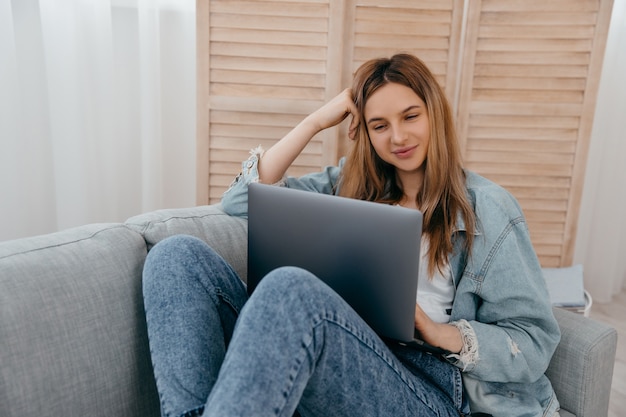 Vrolijke vrouw die aan laptop werkt