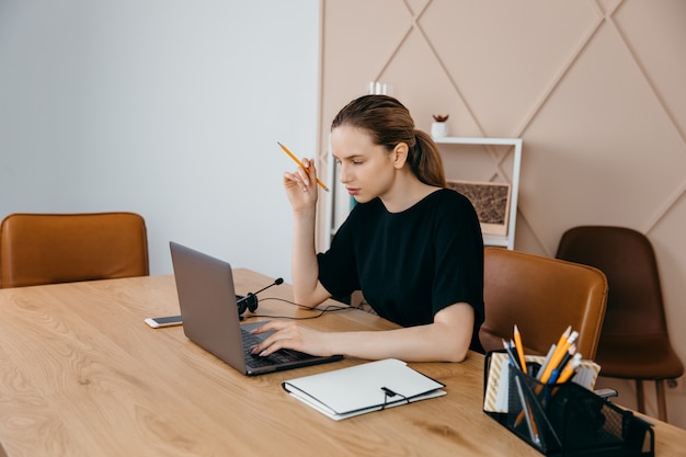 Vrolijke vrouw die aan laptop werkt