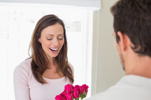 Vrolijke vrouw die bloemen met de mens bekijkt