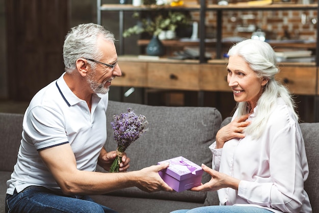 Vrolijke vrouw die cadeau van man neemt voor verjaardag