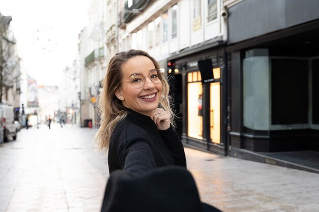 Vrolijke vrouw die met witte glimlach op Europees straat sightseeing lopen.