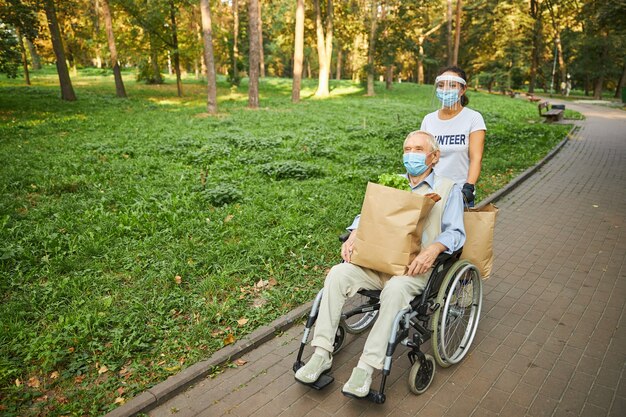 Vrolijke vrouw die voor de oudere man zorgt