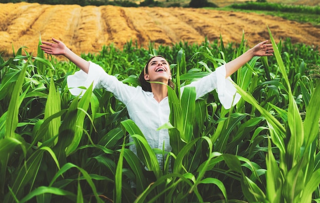 Vrolijke vrouw die zich voordeed in het maïsgewas landbouw- en teeltconcept Amerikaanse vrouw in een wit