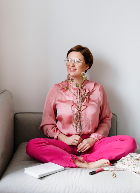 Vrolijke vrouw in een roze shirt met waxflowers