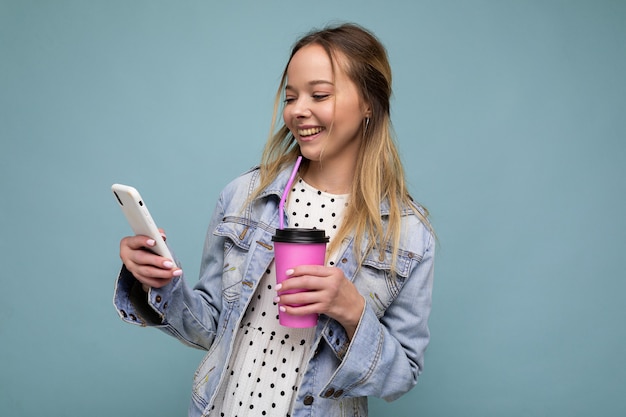 Vrolijke vrouw lacht om bericht terwijl ze koffie drinkt