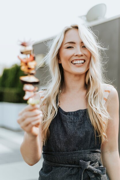 Vrolijke vrouw met een barbecuevleespen