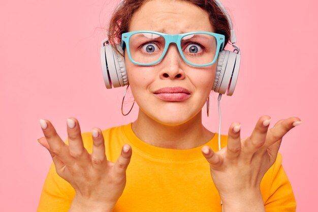 Foto vrolijke vrouw met een blauwe bril die naar muziek luistert op een koptelefoon, een geïsoleerde achtergrond ongewijzigd