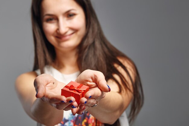 Vrolijke vrouw met een doos met cadeau