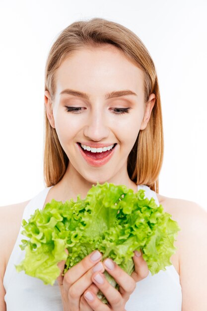 Vrolijke vrouw met groene salade geïsoleerd op een witte achtergrond