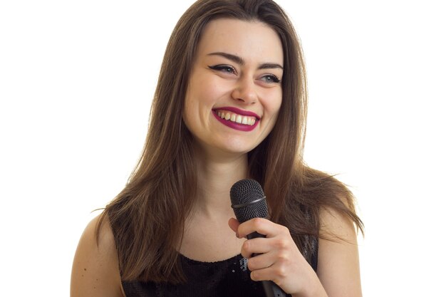 Vrolijke vrouw met mooie make-up lachend met microfoon in handen geïsoleerd op witte achtergrond