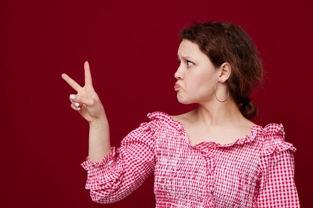 Vrolijke vrouw roze shirt poseren handgebaar