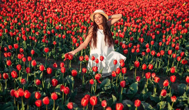 Vrolijke vrouw tussen rode bloemen